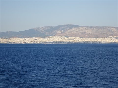 Blue sea before white Athens spreading beneath dry hills