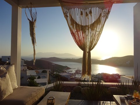 Macramé curtain on a white terrace overlooking the bay at sunset