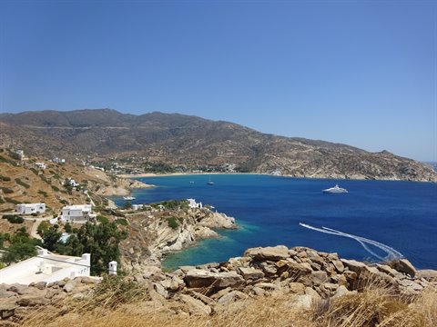 Turquoise bay with a cruising yacht, whitewashed houses and dry hills