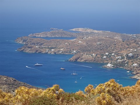Cyclades bay with white boats, arid hills and whitewashed houses