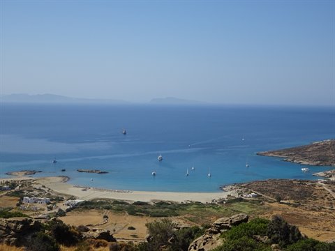 Bay with boats and pale sand, dry hills, blue sky