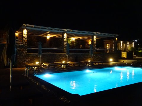 Illuminated pool beside a stone pergola at night, Sifnos