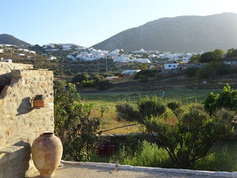 Terracotta amphora on stone wall before whitewashed Apollonia village, Sifnos