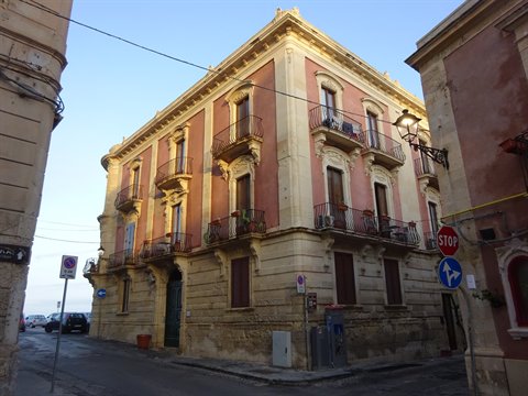 Golden stone Art Nouveau palace with wrought-iron balconies in warm light