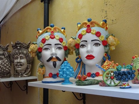 Colorful Sicilian ceramic Moorish heads displayed on a white shelf