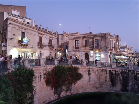 Ortigia, Syracuse: baroque buildings glowing at dusk from Umbertino bridge