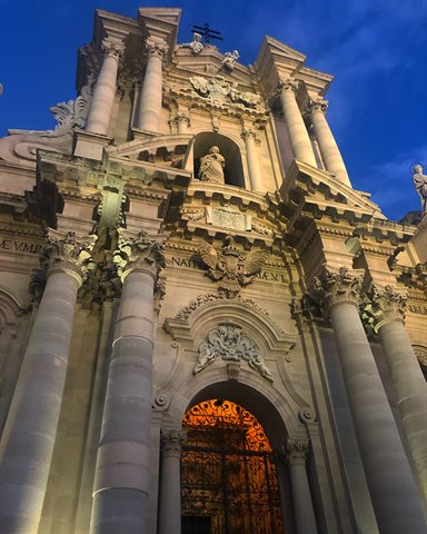 Baroque facade of Syracuse Cathedral illuminated at dusk