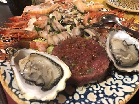 Decorated plate with fresh oysters, tuna tartare, prawns and seafood