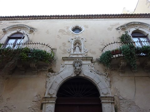 Baroque limestone facade with carved portal, statues and wrought-iron balconies, Syracuse