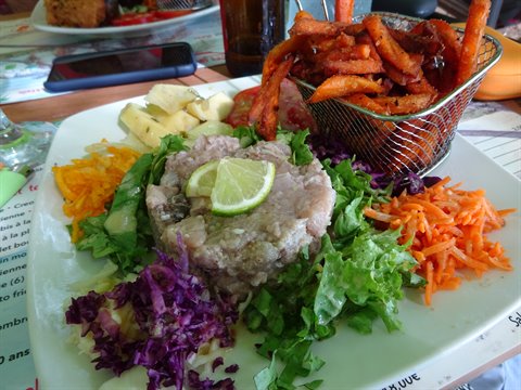 Fish tartare with lime, fresh salads and fries in metal basket