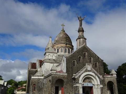 Stone church at Balata, dome and Christ statue against cloudy sky