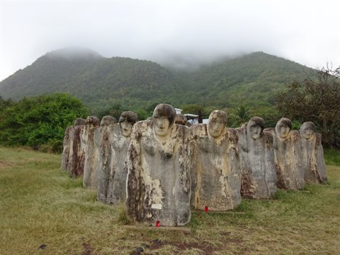 Cap 110 Memorial at Anse Cafard, stone figures on a green lawn
