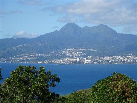 Mount Pelée overlooking Saint-Pierre bay, green trees and blue sea