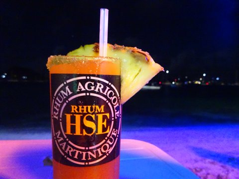 HSE rhum agricole cocktail with pineapple slice, at night on the beach