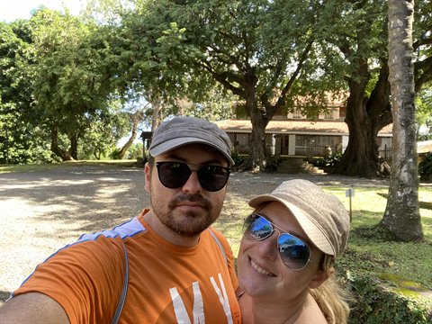 Couple selfie under huge trees in front of a colonial house, Martinique