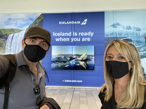 Noi due in mascherina davanti al bancone Icelandair dell'aeroporto