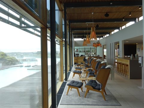 Lounge con poltrone di legno davanti alle acque lattescente della Blue Lagoon