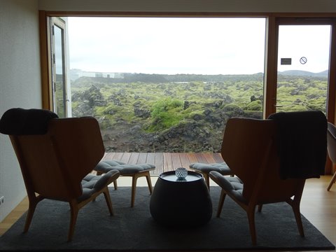 Silence Hotel, due poltrone in legno davanti alle rocce vulcaniche muschiose di Reykjanes