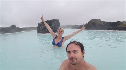 Coppia nella laguna turquoise della Blue Lagoon tra rocce laviche nere