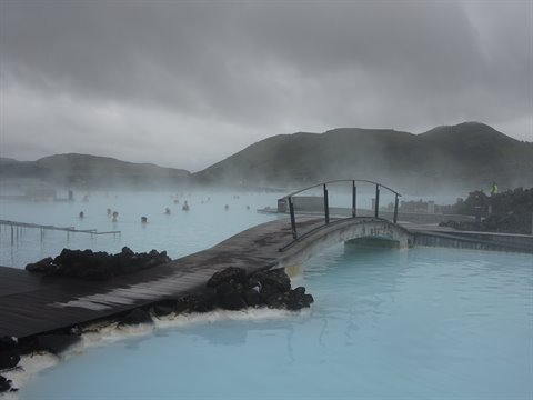 Ponte di legno sull'acqua lattiginosa della Blue Lagoon, bagnanti tra il vapore