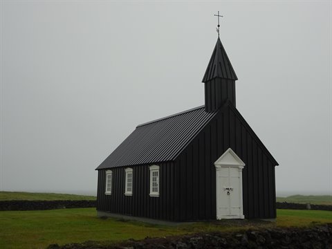La chiesa nera di Búðir tra nebbia e campi verdi