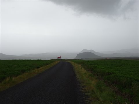 Strada sterrata tra torbiere verdi, nuvole basse sulla penisola di Reykjanes