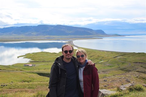 Coppia sorride davanti al fiordo e alle montagne di Akureyri