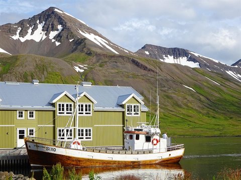 Barca da pesca SI-110 ormeggiata davanti alle case verdi di Siglufjordur