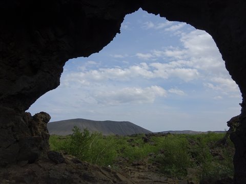 Dall'interno di una grotta di lava, il cratere vulcanico e la vegetazione a Myvatn