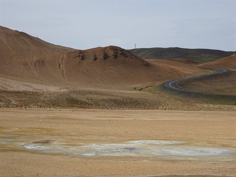 Strada asfaltata tra colline vulcaniche ocre vicino a Mývatn