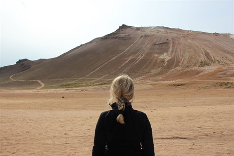 Donna bionda davanti alla montagna rossa di Námafjall vicino Mývatn