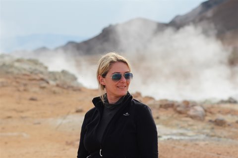 Donna sorridente tra i fumaroli solforosi di Myvatn