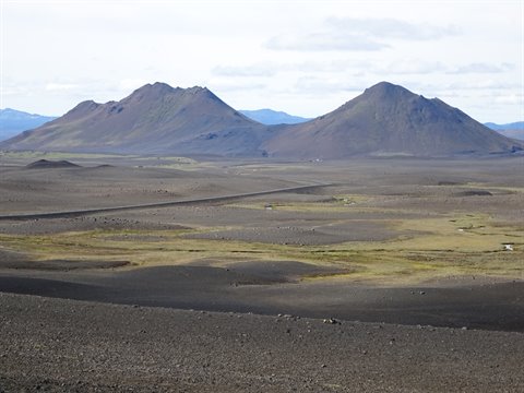 Coni vulcanici scuri sopra pianura lavica con muschio, vicino Mývatn