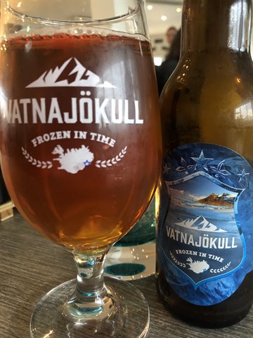 Boccale di birra Vatnajökull accanto alla bottiglia, su tavolo di legno