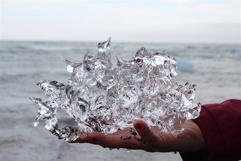Un frammento di ghiaccio trasparente sollevato dalla spiaggia a Jokulsarlon