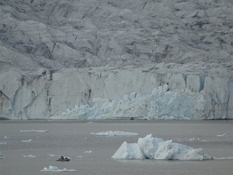 Gommone tra ghiacci galleggianti sotto la parete del ghiacciaio, Jokulsarlon