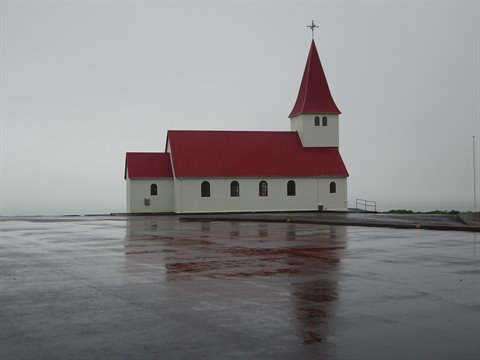 Chiesa con tetto rosso sotto la pioggia a Arnastapi