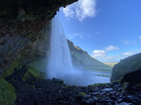 Dietro la cascata Seljalandsfoss, acqua che cade tra muschio e rocce bagnate