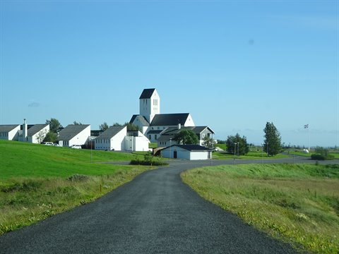 Strada di asfalto verso la chiesa bianca di Skálholt