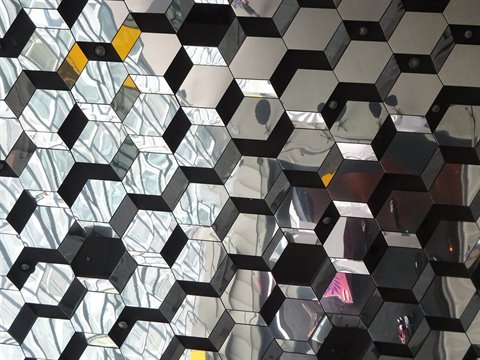 Facciata in vetro esagonale dell'Harpa a Reykjavik, riflessi sulla città