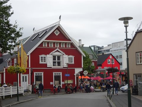 Case in legno rosse e ombrelloni in piazza nel centro di Reykjavik