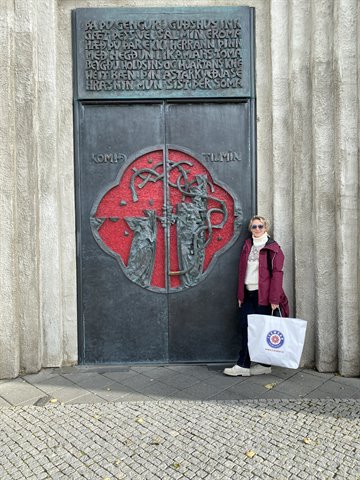 Donna accanto alla grande porta bronzea scolpita della Hallgrímskirkja, Reykjavik