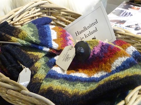 Guanti e calzini di lana colorata lavorati a mano in un cesto di vimini