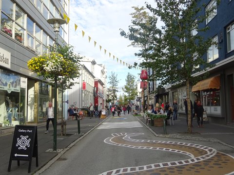 Via pedonale con strisce dipinte, bandierine e negozi a Reykjavik
