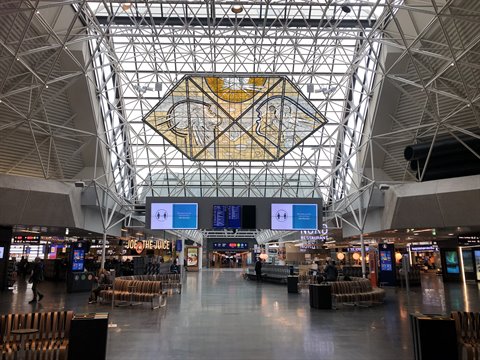 Hall dell'aeroporto con struttura in acciaio e vetro, luminoso sfondo