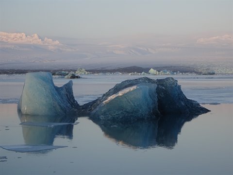 Blue icebergs reflected in the calm water of Jökulsárlón lagoon