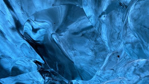 Striated blue glacier ice, soft light filters through the icy walls