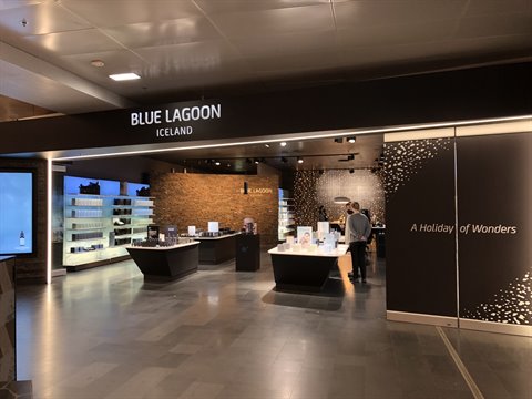 Customer browses a skincare store, warm lighting, reflective floor, glowing sign above