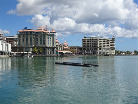 Colonial buildings overlooking the harbor, turquoise water, floating pontoon in foreground