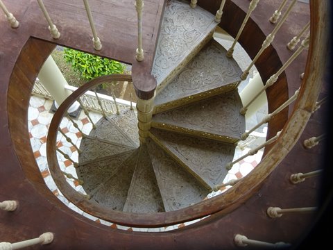 Spiral staircase in wood and metal seen from above, natural light